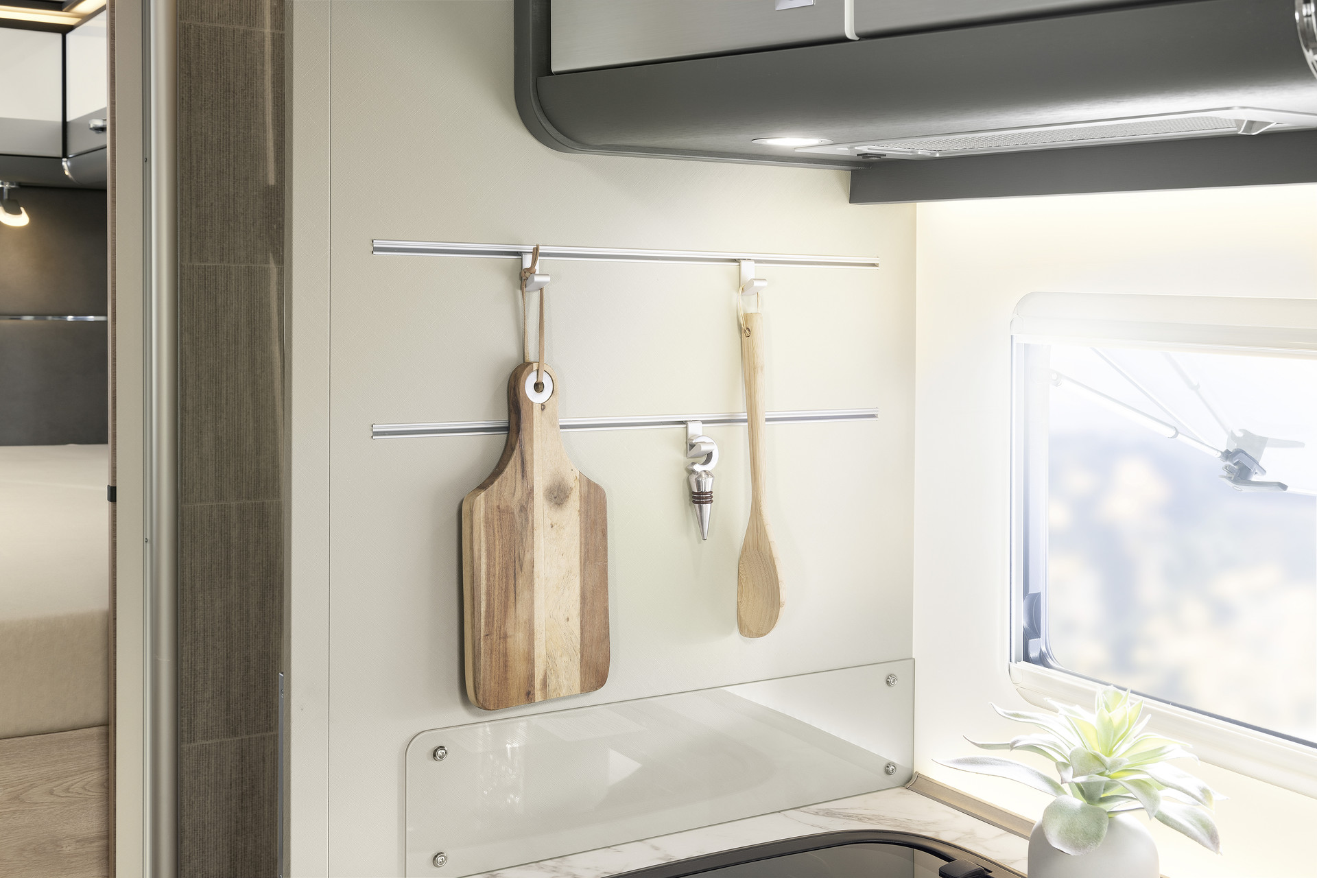 Système de rails permettant de poser ou d’ac- crocher les divers accessoires de cuisine, si pra- tiques et indispensables